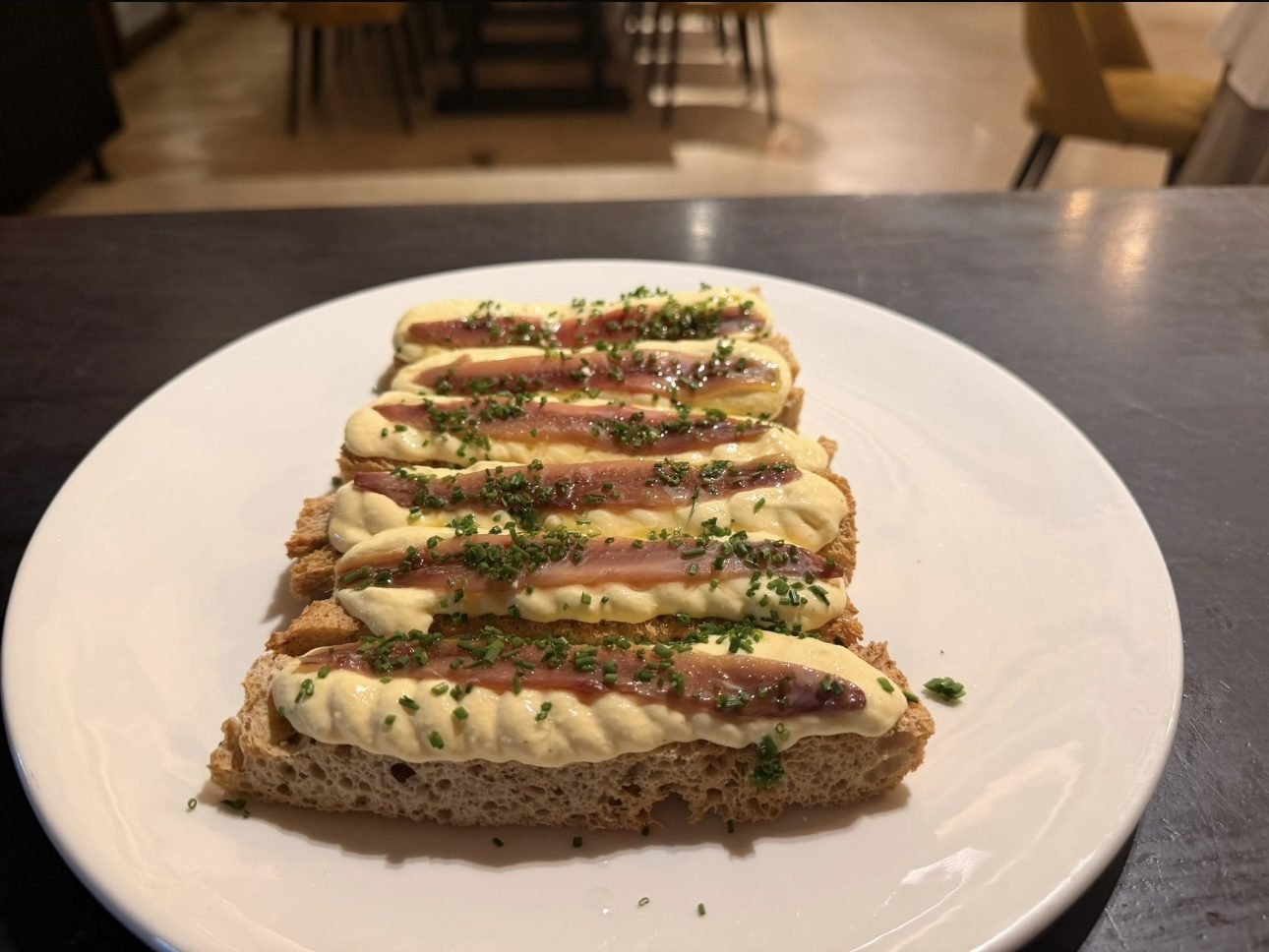 Anchovy toast served on a white plate